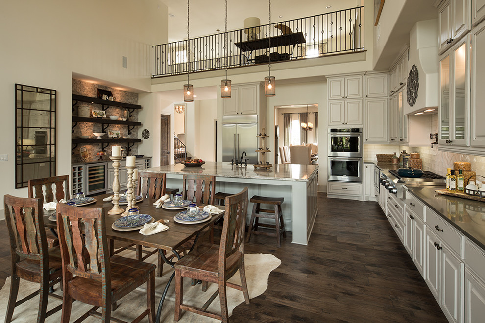Inspiration for a mediterranean galley dark wood floor and brown floor open concept kitchen remodel in Austin with white cabinets, white backsplash, stainless steel appliances, an island and a farmhouse sink