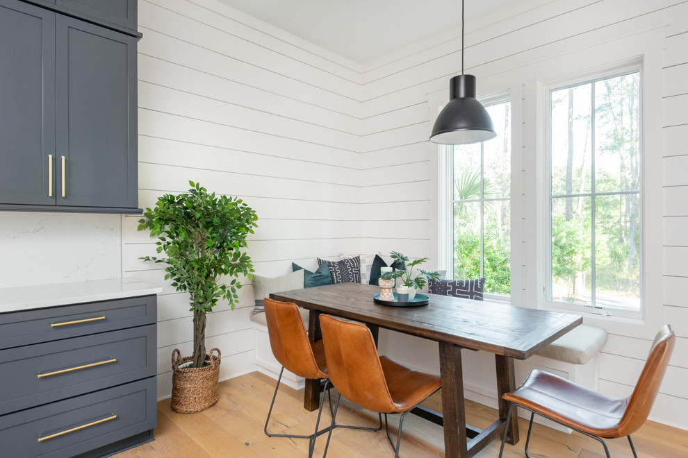 Immagine di una cucina costiera con pavimento in legno massello medio, pavimento marrone, ante in stile shaker, ante blu, paraspruzzi bianco, elettrodomestici in acciaio inossidabile e top bianco
