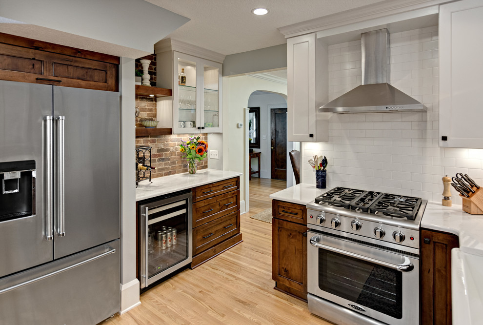 Bild på ett mellanstort rustikt kök och matrum, med en rustik diskho, släta luckor, bänkskiva i kvarts, flerfärgad stänkskydd, stänkskydd i tunnelbanekakel, rostfria vitvaror, ljust trägolv, en köksö och brunt golv