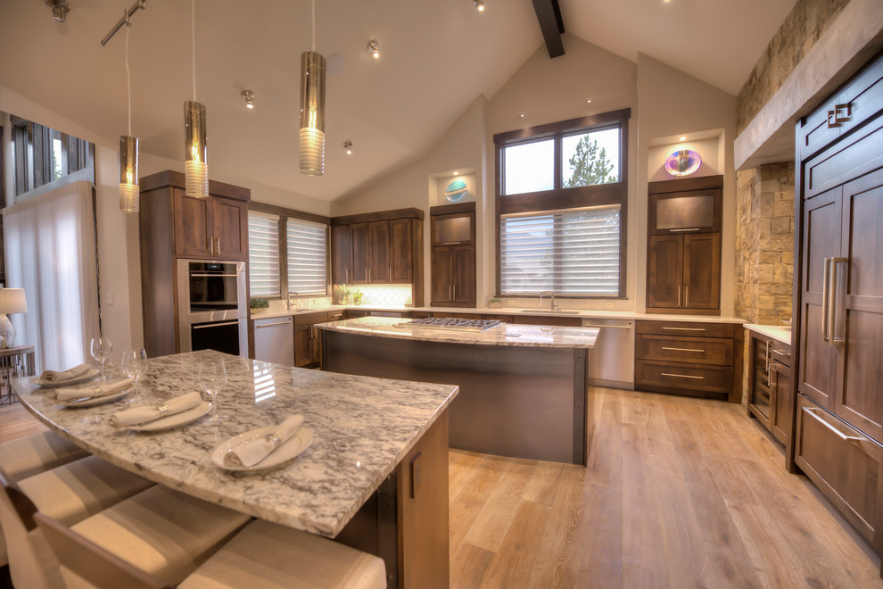 Photo of a large traditional u-shaped open plan kitchen in Other with a submerged sink, shaker cabinets, dark wood cabinets, granite worktops, multi-coloured splashback, glass tiled splashback, stainless steel appliances, light hardwood flooring, multiple islands and multi-coloured floors.