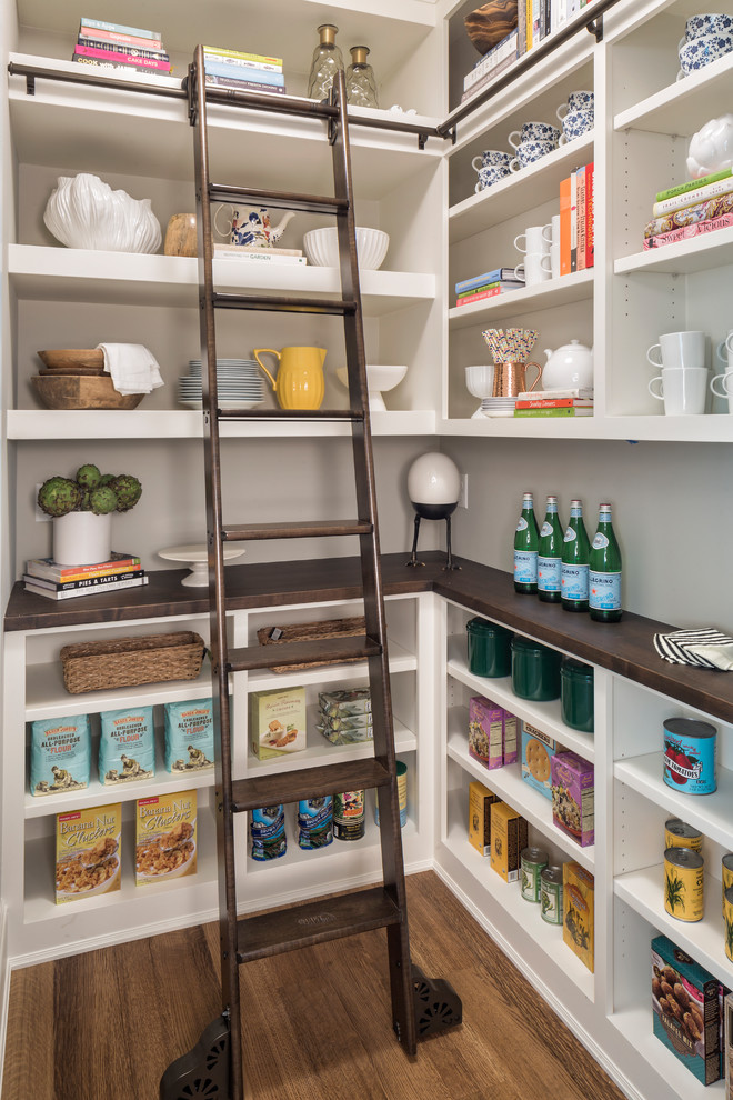 Example of a classic l-shaped medium tone wood floor and brown floor kitchen pantry design in Minneapolis with open cabinets, white cabinets and brown countertops