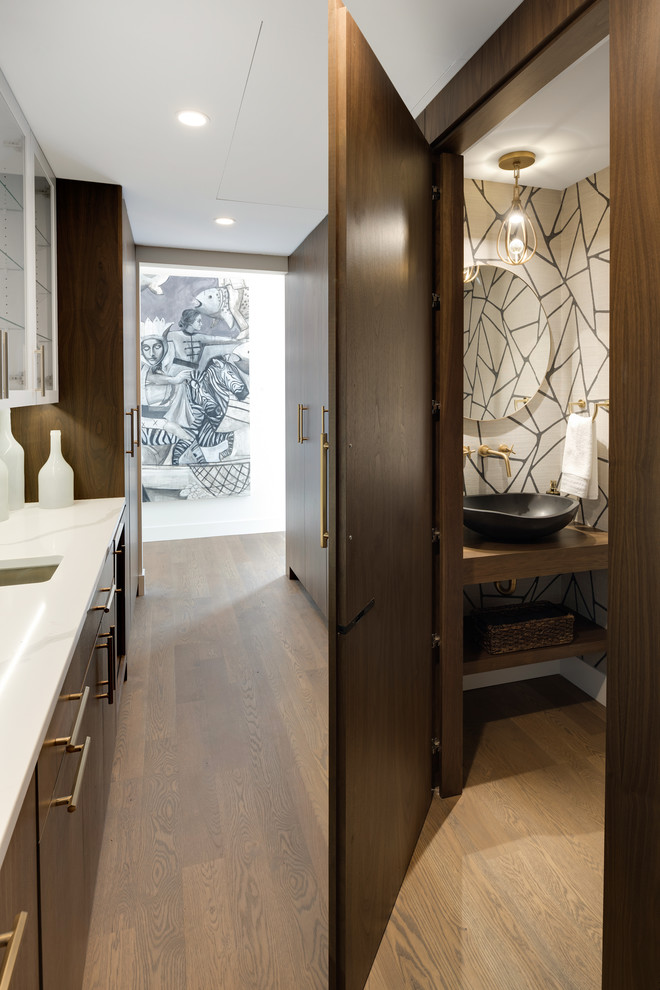Inspiration for a large modern galley light wood floor and gray floor kitchen pantry remodel in Minneapolis with an undermount sink, flat-panel cabinets, medium tone wood cabinets, quartz countertops, white backsplash, ceramic backsplash, paneled appliances, an island and white countertops