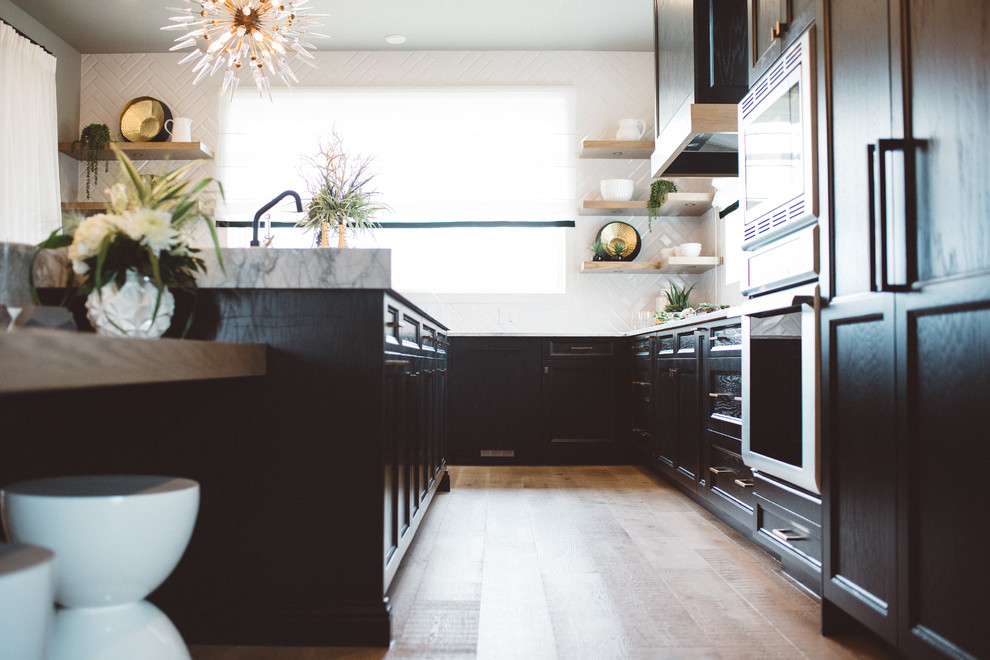 Inspiration för ett mellanstort funkis grå grått kök, med en undermonterad diskho, luckor med infälld panel, svarta skåp, marmorbänkskiva, vitt stänkskydd, stänkskydd i keramik, rostfria vitvaror, heltäckningsmatta, en köksö och grått golv