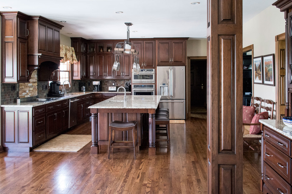 Idéer för ett stort klassiskt flerfärgad kök, med en undermonterad diskho, luckor med upphöjd panel, skåp i mörkt trä, granitbänkskiva, flerfärgad stänkskydd, stänkskydd i skiffer, rostfria vitvaror, mellanmörkt trägolv, en köksö och brunt golv