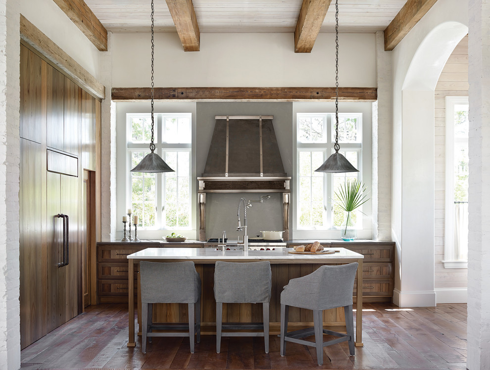 Immagine di un cucina con isola centrale stile marinaro con ante in legno scuro, paraspruzzi grigio, elettrodomestici da incasso e pavimento in legno massello medio