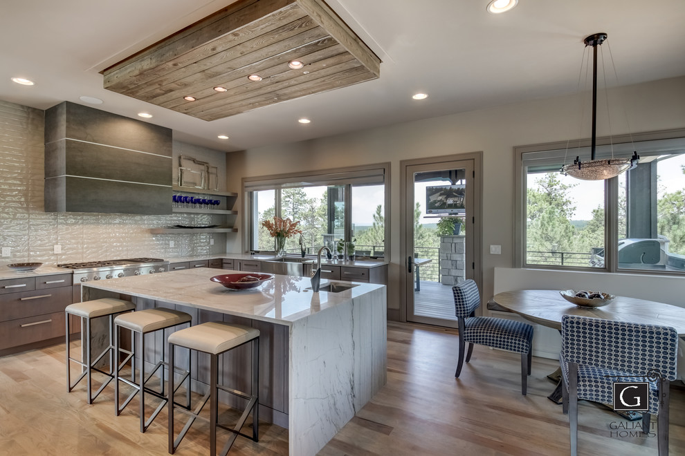 Mid-sized minimalist l-shaped light wood floor and gray floor eat-in kitchen photo in Denver with a farmhouse sink, flat-panel cabinets, gray cabinets, quartzite countertops, glass tile backsplash, stainless steel appliances, an island and white countertops