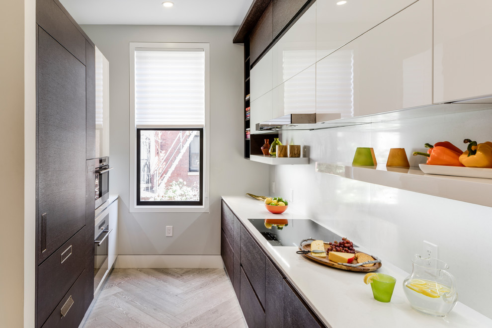 Ejemplo de cocina contemporánea con armarios con paneles lisos, salpicadero blanco y electrodomésticos de acero inoxidable