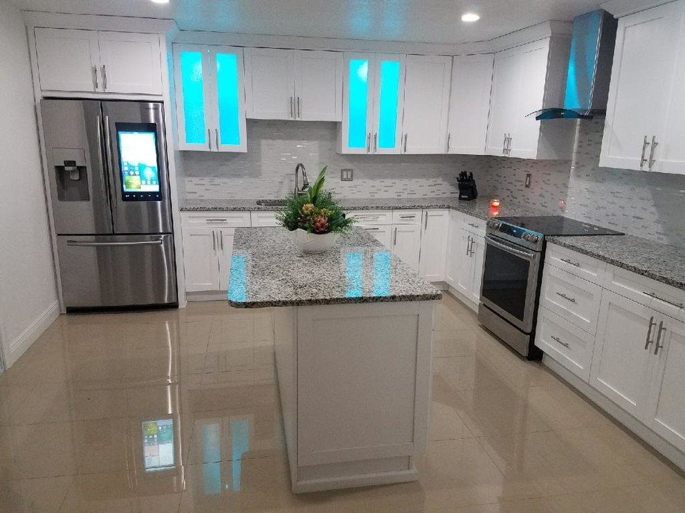 This is an example of a large modern galley kitchen/diner in Tampa with a double-bowl sink, flat-panel cabinets, white cabinets, granite worktops, multi-coloured splashback, cement tile splashback, stainless steel appliances, cement flooring, an island, brown floors and grey worktops.