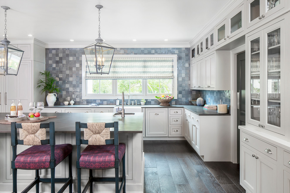 Photo of a classic l-shaped kitchen in Austin with grey cabinets, an island, a belfast sink, shaker cabinets, blue splashback, dark hardwood flooring, brown floors and black worktops.