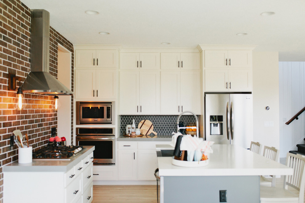 Exempel på ett mellanstort modernt vit vitt kök och matrum, med en rustik diskho, skåp i shakerstil, vita skåp, bänkskiva i kvarts, rött stänkskydd, stänkskydd i tegel, rostfria vitvaror, laminatgolv, en köksö och vitt golv