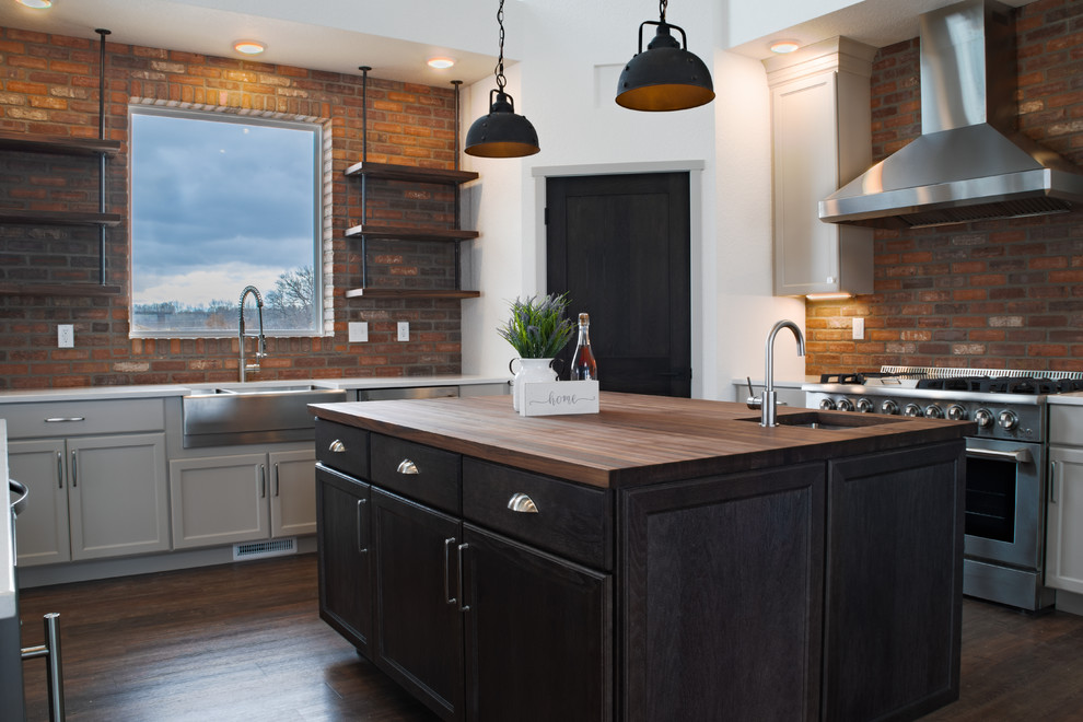 Inspiration for a large industrial u-shaped vinyl floor and brown floor open concept kitchen remodel in Other with a farmhouse sink, shaker cabinets, white cabinets, quartz countertops, white backsplash, brick backsplash, stainless steel appliances, two islands and white countertops