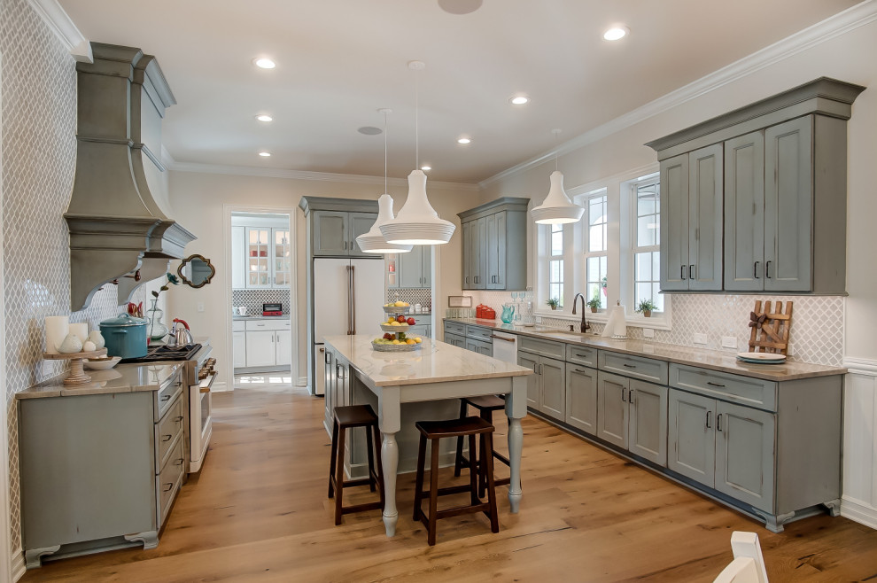 Kitchen - transitional u-shaped medium tone wood floor and brown floor kitchen idea in Columbus with an undermount sink, recessed-panel cabinets, green cabinets, gray backsplash, white appliances, an island and beige countertops