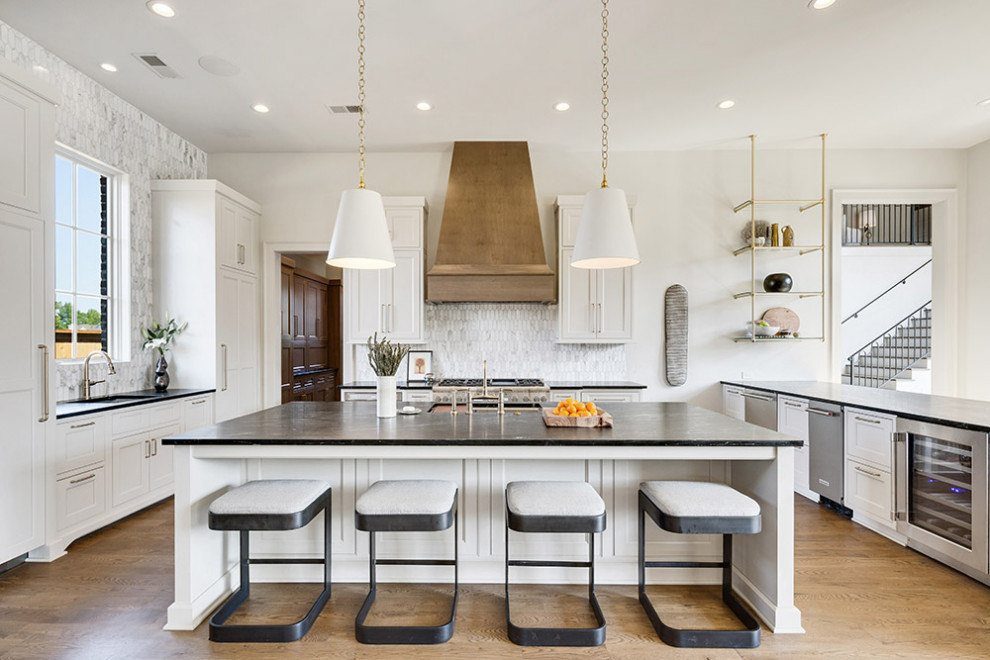 Inspiration for a mid-sized transitional l-shaped light wood floor and brown floor enclosed kitchen remodel in Other with a double-bowl sink, recessed-panel cabinets, white cabinets, onyx countertops, white backsplash, ceramic backsplash, stainless steel appliances, an island and black countertops