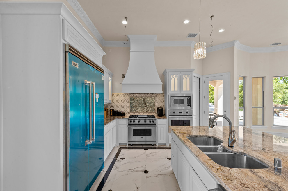 Example of a large tuscan u-shaped porcelain tile and white floor open concept kitchen design in Dallas with an undermount sink, shaker cabinets, white cabinets, granite countertops, beige backsplash, porcelain backsplash, stainless steel appliances, an island and beige countertops
