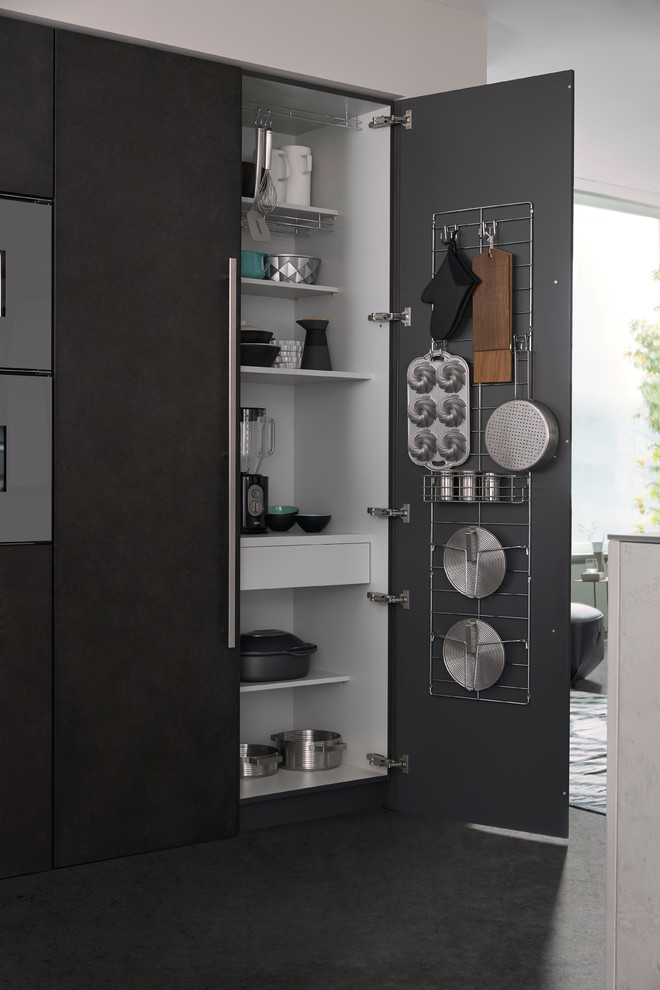 Esempio di una cucina minimalista di medie dimensioni con lavello da incasso, ante lisce, ante grigie, top in superficie solida, paraspruzzi bianco, elettrodomestici in acciaio inossidabile e pavimento in cemento