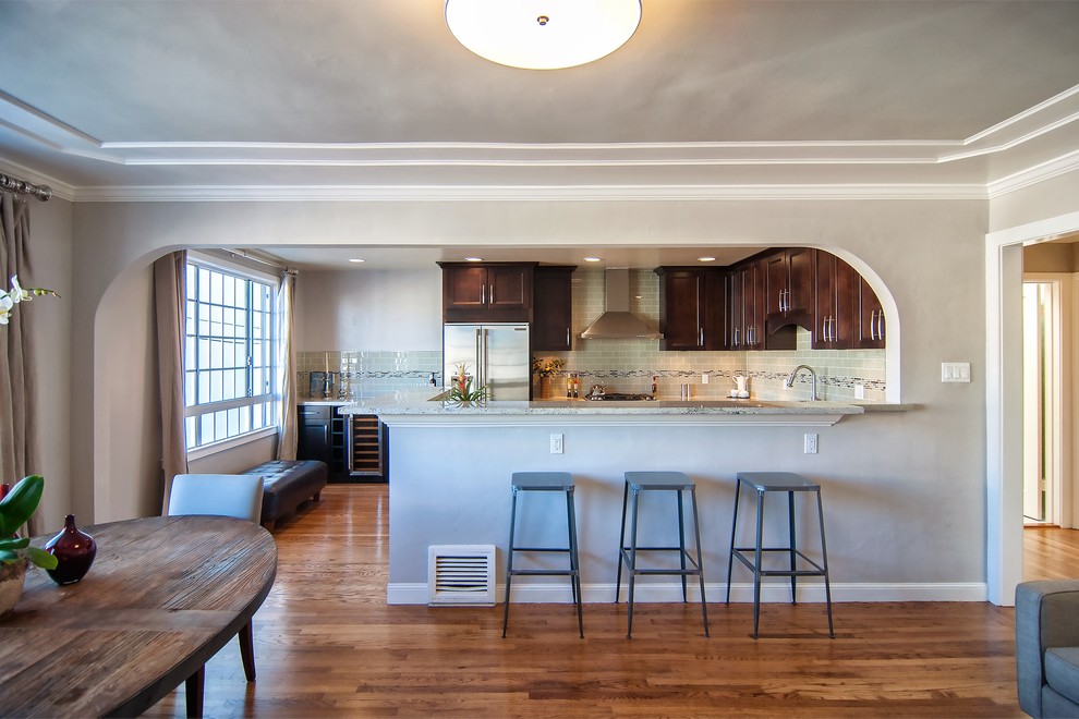 Mittelgroße Moderne Wohnküche in L-Form mit Kücheninsel, Schrankfronten mit vertiefter Füllung, dunklen Holzschränken, Marmor-Arbeitsplatte, bunter Rückwand, Küchengeräten aus Edelstahl, Doppelwaschbecken und braunem Holzboden in San Francisco