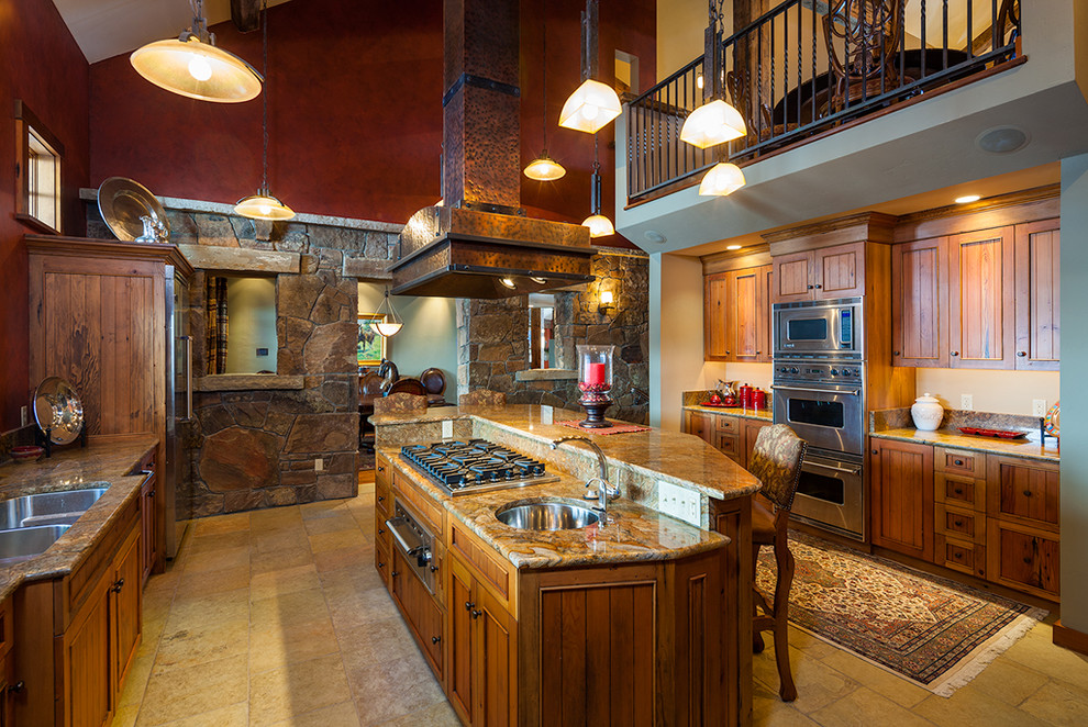 Rustik inredning av ett mycket stort kök, med granitbänkskiva, travertin golv och en köksö