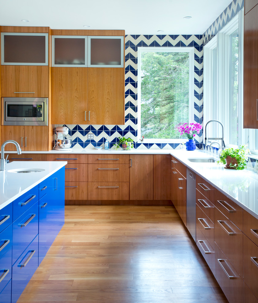 Idee per una cucina minimal con lavello sottopiano, ante lisce, ante blu, paraspruzzi blu, elettrodomestici in acciaio inossidabile, pavimento in legno massello medio e pavimento arancione