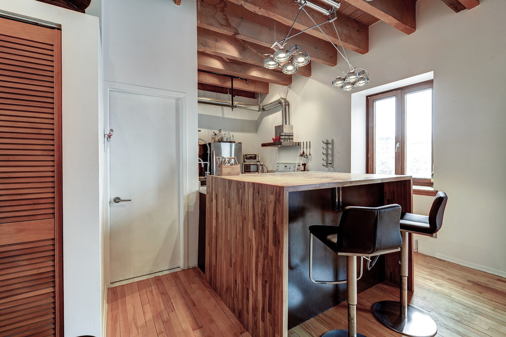 Kleine Industrial Küche in U-Form mit Landhausspüle, flächenbündigen Schrankfronten, Marmor-Arbeitsplatte, Küchengeräten aus Edelstahl und Kücheninsel in Montreal