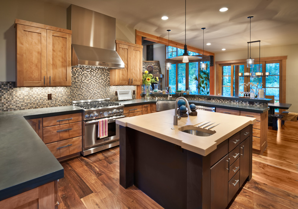 Example of a mountain style u-shaped dark wood floor eat-in kitchen design in Sacramento with a farmhouse sink, shaker cabinets, medium tone wood cabinets, multicolored backsplash, mosaic tile backsplash, stainless steel appliances and an island