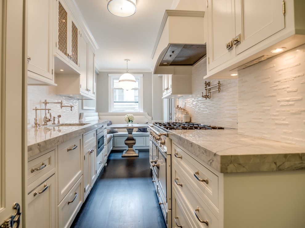 Inspiration for a mid-sized transitional galley dark wood floor and brown floor enclosed kitchen remodel in New York with an undermount sink, beaded inset cabinets, white cabinets, marble countertops, white backsplash, stone tile backsplash, paneled appliances, no island and gray countertops