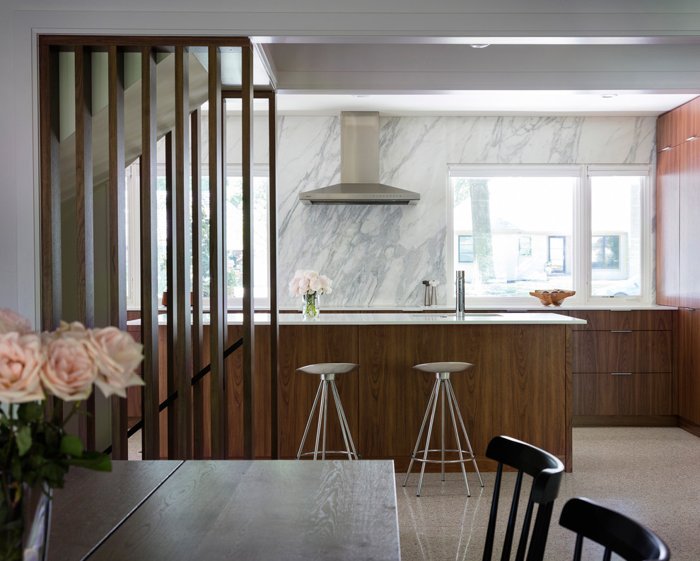 Foto di una grande cucina contemporanea con ante lisce, ante in legno bruno, top in superficie solida, paraspruzzi bianco, paraspruzzi in lastra di pietra e pavimento in cemento