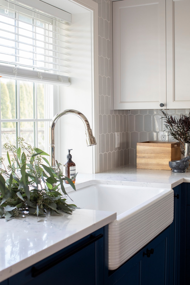Exempel på ett lantligt vit vitt kök, med en undermonterad diskho, skåp i shakerstil, bänkskiva i kvartsit, blått stänkskydd, rostfria vitvaror, mellanmörkt trägolv och en köksö
