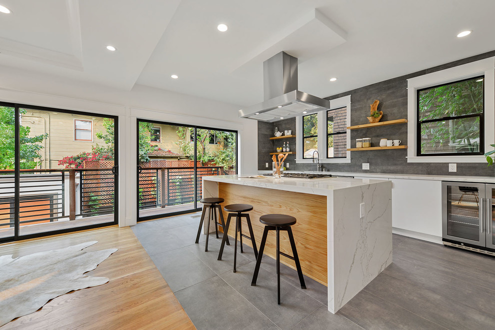 Large contemporary grey and cream l-shaped open plan kitchen in San Francisco with a submerged sink, flat-panel cabinets, white cabinets, marble worktops, stainless steel appliances, an island, grey splashback, grey floors and white worktops.