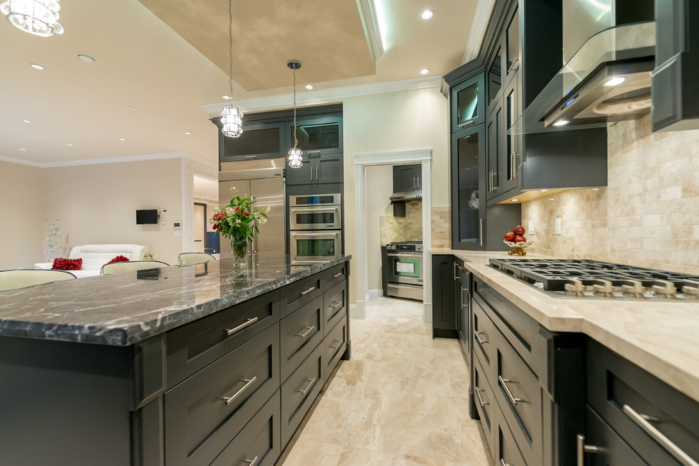 This is an example of a large contemporary u-shaped open plan kitchen in Vancouver with a submerged sink, shaker cabinets, black cabinets, granite worktops, beige splashback, stone tiled splashback, stainless steel appliances, marble flooring, an island, beige floors and multicoloured worktops.