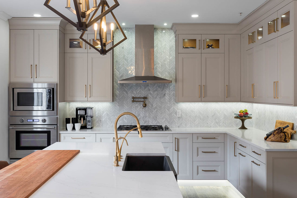 Large transitional l-shaped dark wood floor and brown floor eat-in kitchen photo in Vancouver with a farmhouse sink, shaker cabinets, gray cabinets, quartz countertops, an island, white countertops, gray backsplash and marble backsplash