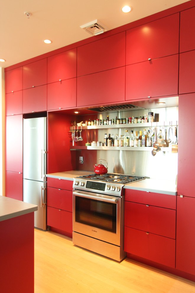 Bild på ett litet funkis kök med öppen planlösning, med en undermonterad diskho, släta luckor, röda skåp, bänkskiva i koppar, stänkskydd i metallkakel, rostfria vitvaror, mellanmörkt trägolv och en köksö