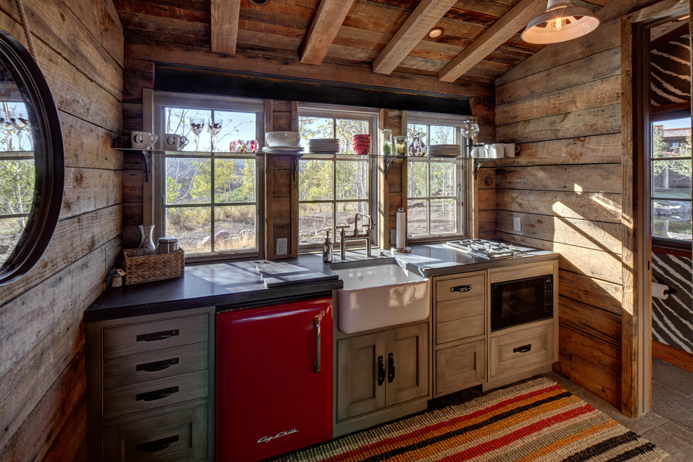 Foto di una piccola cucina lineare rustica chiusa con lavello stile country, ante in legno scuro, elettrodomestici colorati, pavimento in legno massello medio e nessuna isola