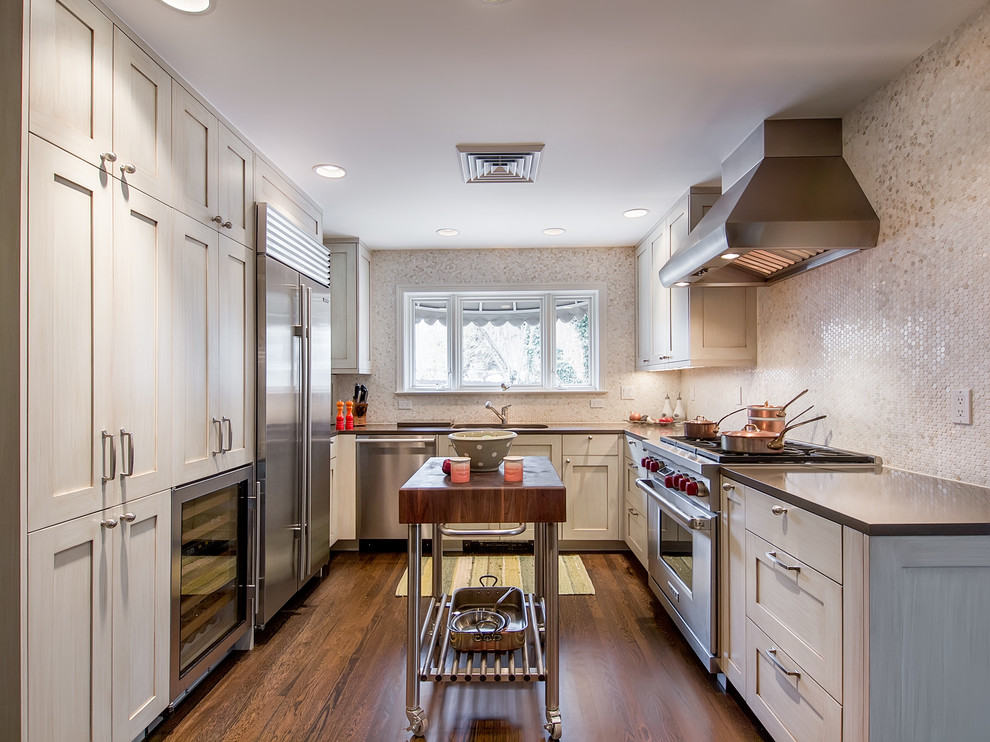 Inspiration for a contemporary u-shaped enclosed kitchen remodel in Denver with stainless steel appliances, an undermount sink, shaker cabinets, beige cabinets, beige backsplash and mosaic tile backsplash