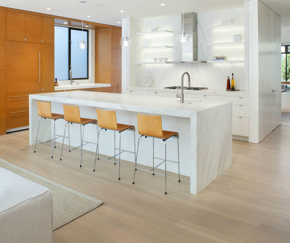Large contemporary l-shaped open plan kitchen in San Francisco with open cabinets, white cabinets, white splashback, integrated appliances, light hardwood flooring, an island, a submerged sink, marble worktops and stone slab splashback.