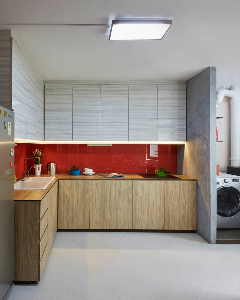 Inspiration for a medium sized modern l-shaped kitchen in Singapore with a double-bowl sink, shaker cabinets, medium wood cabinets, wood worktops, red splashback, glass sheet splashback, stainless steel appliances and ceramic flooring.