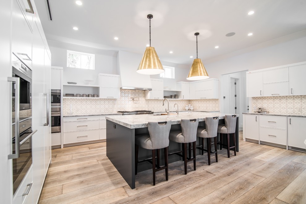 Inspiration for a transitional light wood floor kitchen remodel in Miami with white cabinets, multicolored backsplash, stainless steel appliances and an island