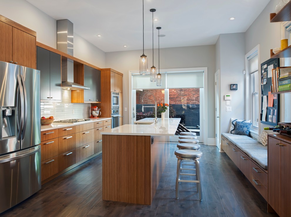 Contemporary kitchen in Philadelphia with a belfast sink, flat-panel cabinets, medium wood cabinets, engineered stone countertops, glass tiled splashback, stainless steel appliances and medium hardwood flooring.