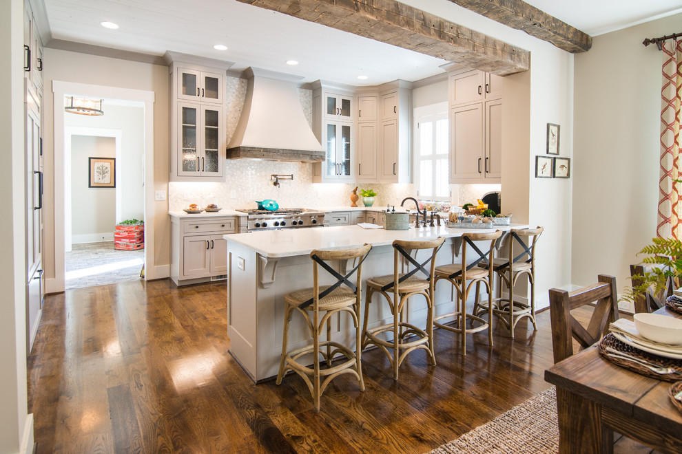 Inspiration for a mid-sized transitional u-shaped medium tone wood floor eat-in kitchen remodel in Atlanta with a farmhouse sink, shaker cabinets, gray cabinets, white backsplash, ceramic backsplash and stainless steel appliances
