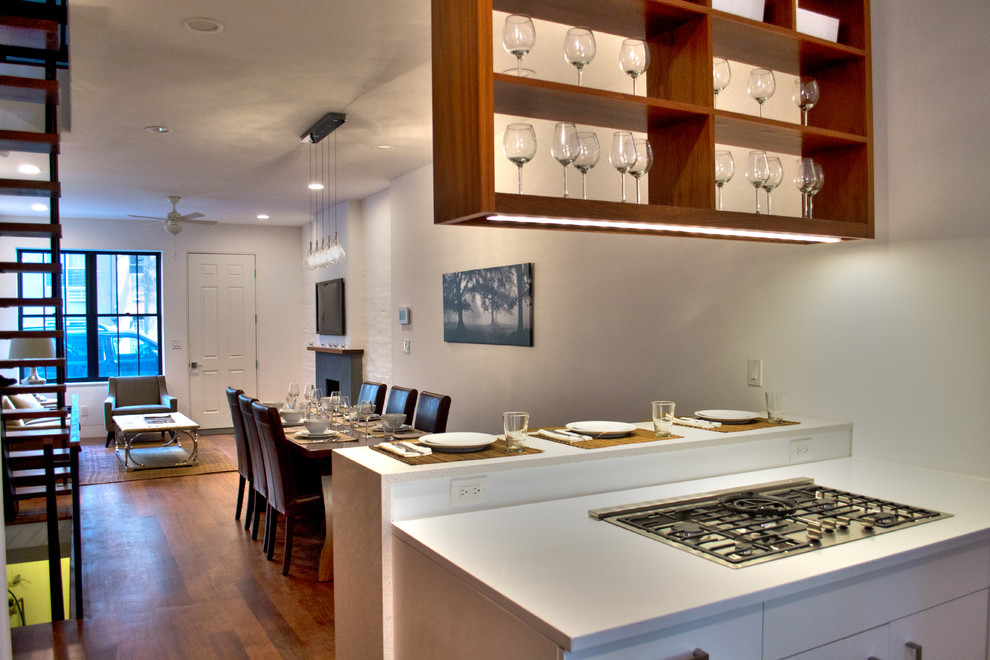 Immagine di una cucina moderna di medie dimensioni con ante lisce, ante in legno scuro, elettrodomestici in acciaio inossidabile, pavimento in legno massello medio e nessuna isola