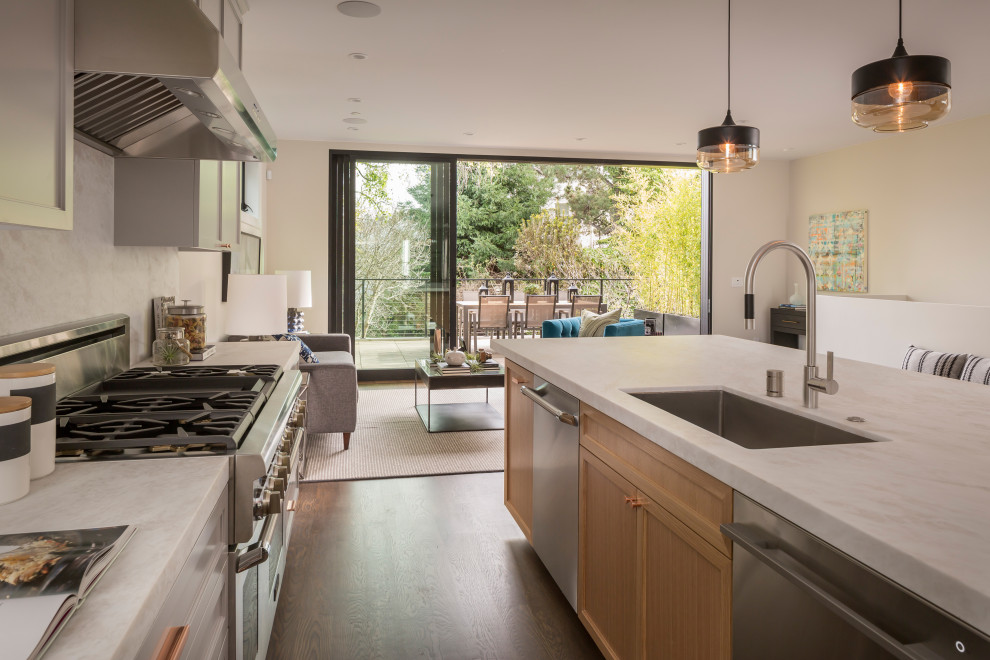Mid-sized transitional l-shaped medium tone wood floor open concept kitchen photo in San Francisco with an undermount sink, shaker cabinets, light wood cabinets, marble countertops, white backsplash, marble backsplash, stainless steel appliances, an island and white countertops
