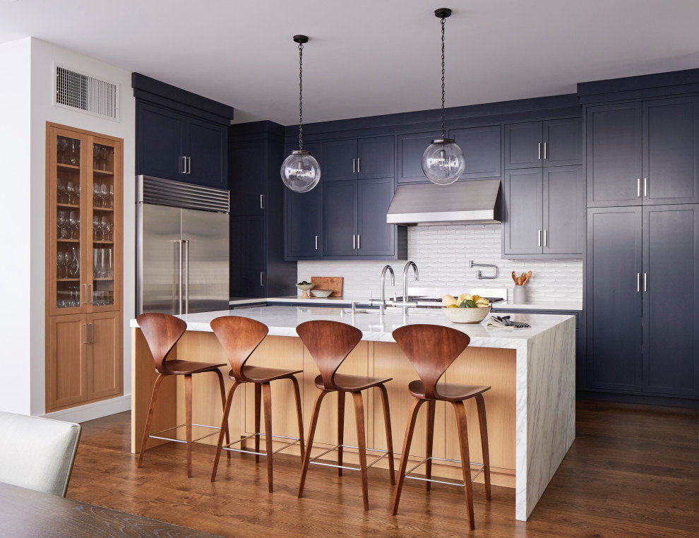 Foto di un'ampia cucina classica con lavello sottopiano, ante in stile shaker, ante blu, paraspruzzi bianco, elettrodomestici in acciaio inossidabile, pavimento marrone e top bianco