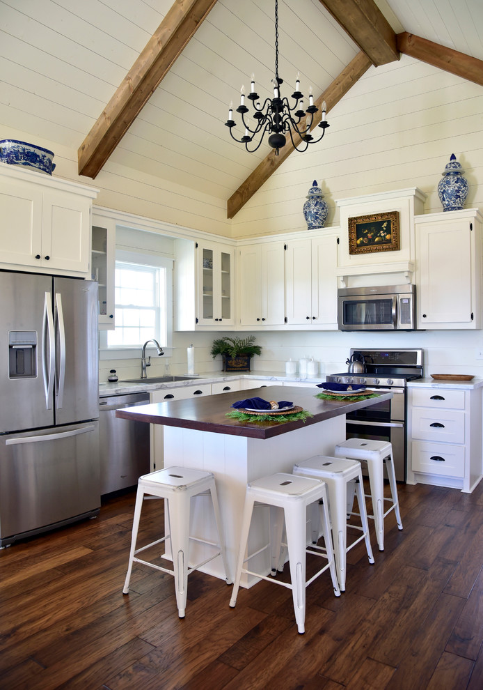 Inspiration for a mid-sized farmhouse l-shaped medium tone wood floor and brown floor kitchen remodel with white cabinets, marble countertops, white backsplash, stainless steel appliances, an island, a single-bowl sink, shaker cabinets and wood backsplash