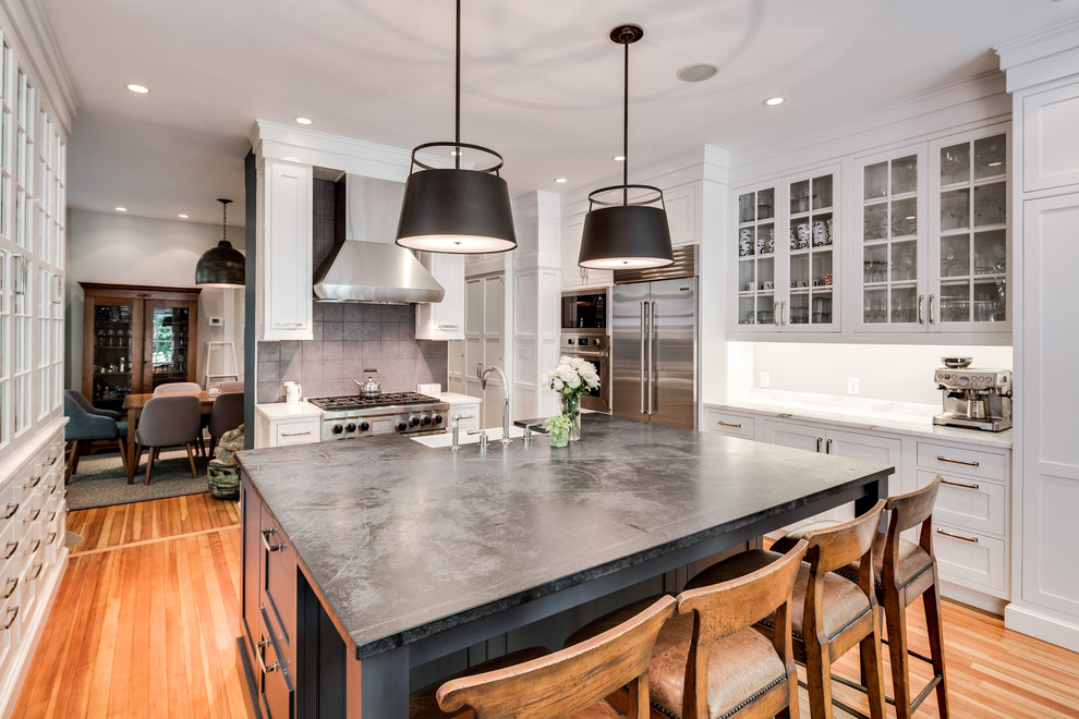 Example of a large transitional u-shaped enclosed kitchen design in DC Metro with a farmhouse sink, glass-front cabinets, white cabinets, concrete countertops and an island