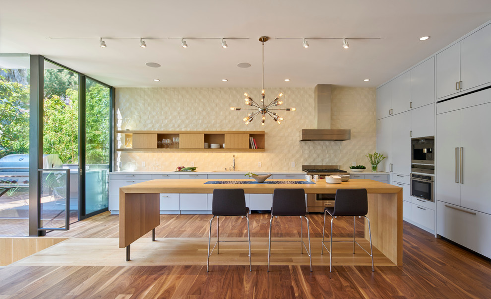 Example of a large trendy single-wall dark wood floor and brown floor kitchen design in San Francisco with flat-panel cabinets, gray cabinets, stainless steel appliances, an island, a double-bowl sink, quartzite countertops, beige backsplash and ceramic backsplash