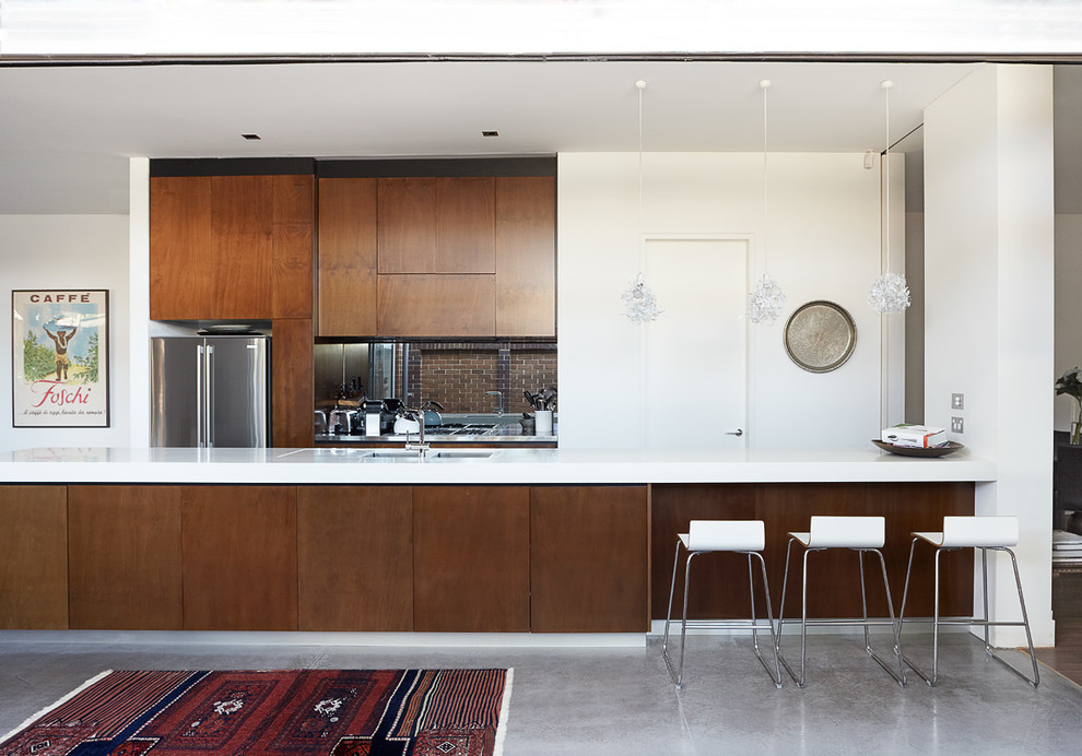 Idéer för ett stort modernt kök, med bänkskiva i kvarts, rostfria vitvaror, betonggolv, släta luckor, skåp i mörkt trä, en halv köksö och en undermonterad diskho