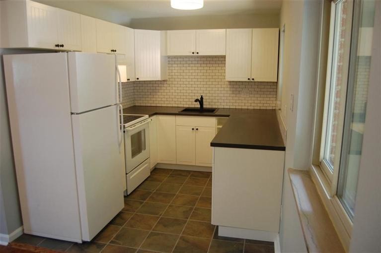 Photo of a small rural kitchen in Cincinnati with raised-panel cabinets and white cabinets.
