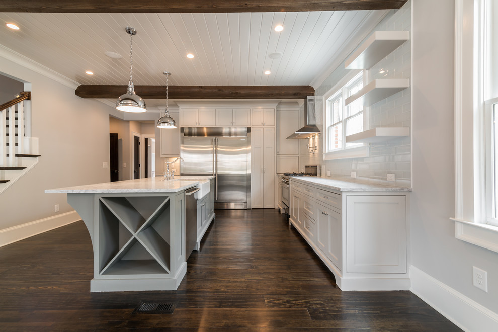 Eat-in kitchen - traditional u-shaped dark wood floor eat-in kitchen idea in Atlanta with a farmhouse sink, beaded inset cabinets, white cabinets, marble countertops, white backsplash, glass tile backsplash, stainless steel appliances and an island