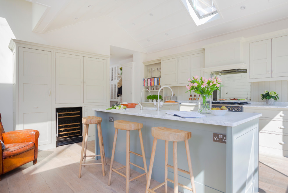 Inspiration for a traditional kitchen/diner in Surrey with shaker cabinets and an island.