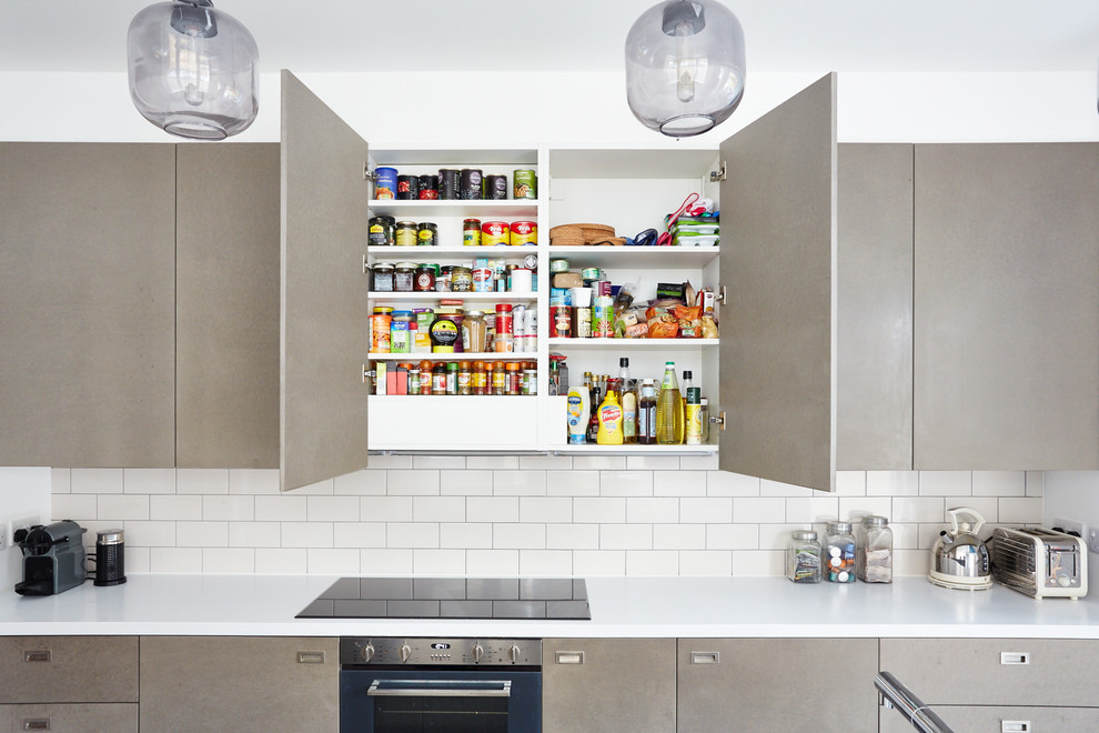 Inspiration for a contemporary kitchen remodel in London with flat-panel cabinets and an island