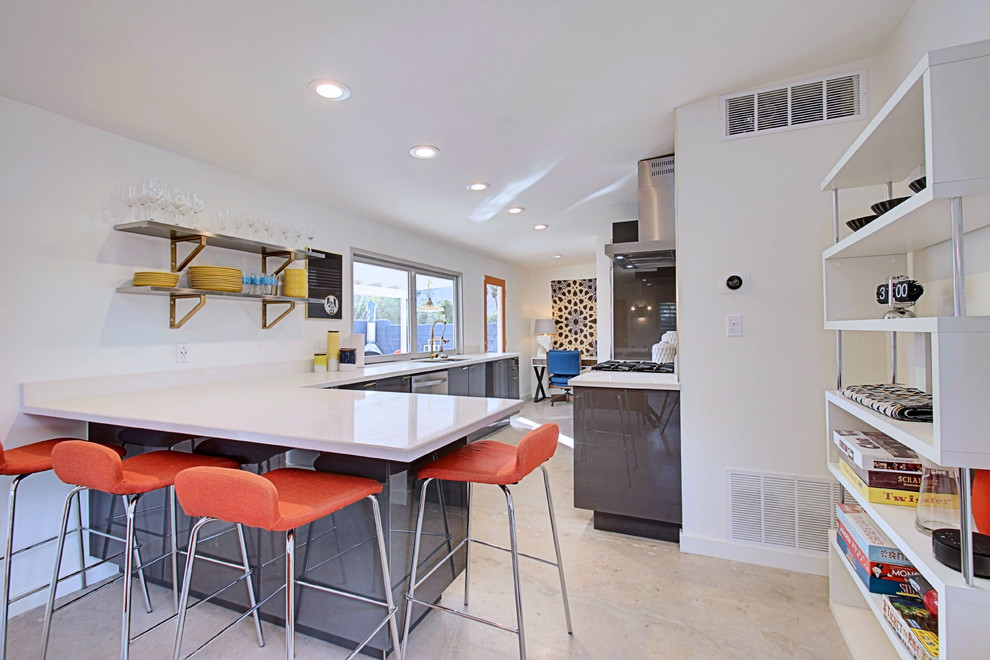 Open concept kitchen - mid-sized 1960s l-shaped concrete floor open concept kitchen idea in Phoenix with an undermount sink, flat-panel cabinets, gray cabinets, quartz countertops, yellow backsplash, ceramic backsplash, stainless steel appliances and a peninsula